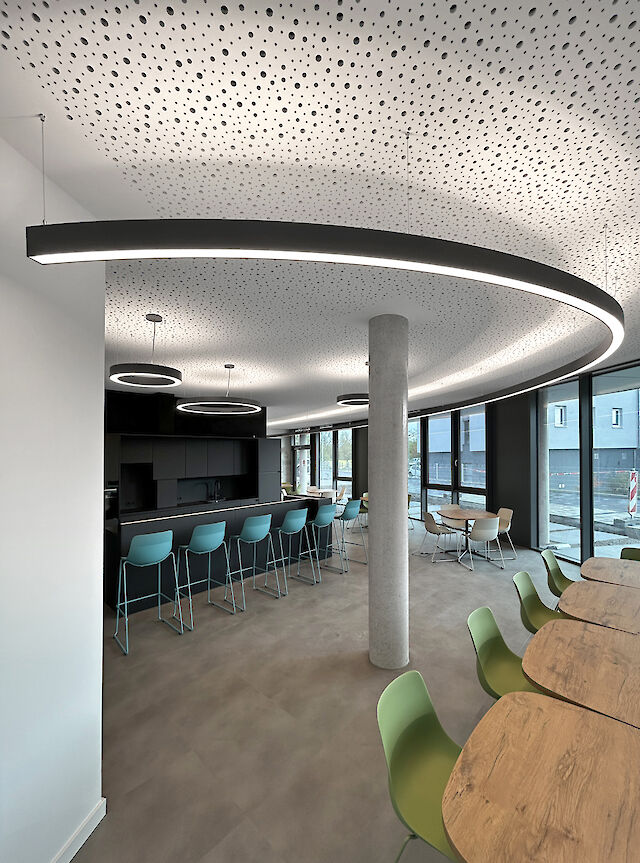 The modern interior of the new town hall in Viernheim combines contemporary design with functional lighting. The picture shows the Liquid Line luminaires from Lightnet, which elegantly emphasise the curved architecture of the room. The matt black light lines fit seamlessly into the overall concept and provide glare-free, harmonious illumination. The flexible work and meeting areas are optimally presented through the interplay of natural daylight and energy-efficient LED technology. Perfect lighting for public spaces with high aesthetic and sustainability standards.

