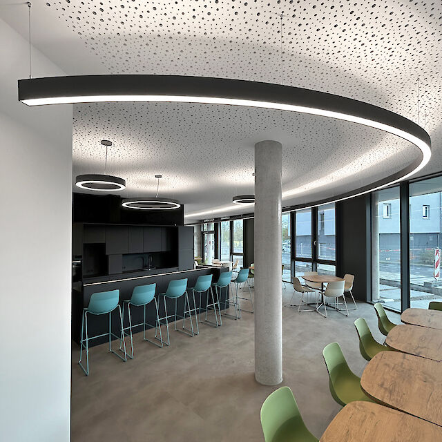 El moderno interior del nuevo ayuntamiento de Viernheim combina un diseño contemporáneo con una iluminación funcional. La imagen muestra las luminarias Liquid Line de Lightnet, que realzan con elegancia la arquitectura curva de la sala. Las líneas de luz en negro mate se integran perfectamente en el concepto global y garantizan una iluminación armoniosa y sin deslumbramientos. La interacción de la luz natural y la tecnología LED de bajo consumo realza a la perfección las zonas flexibles de trabajo y reunión. Una iluminación perfecta para espacios públicos que exigen estética y sostenibilidad.

