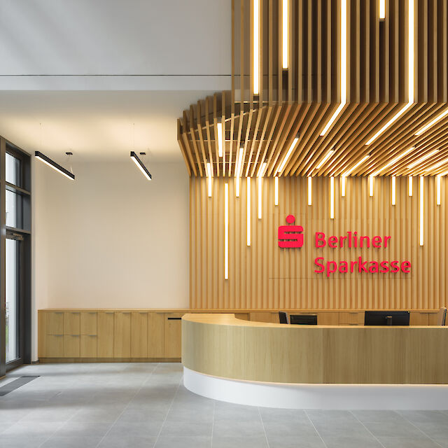 Modernes Bankfoyer der Berliner Sparkasse mit Holzlamellen-Decke und integrierten LED-Leuchten