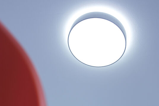 Round Basic surface-mounted luminaire with indirect light on a light blue ceiling.