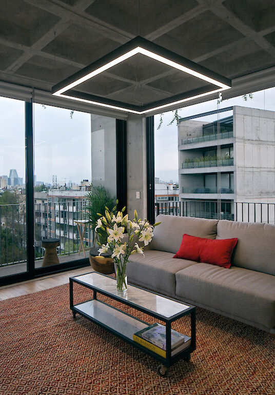 View of the modern lobby with ring-shaped pendant light, marble counter and wooden slatted ceiling