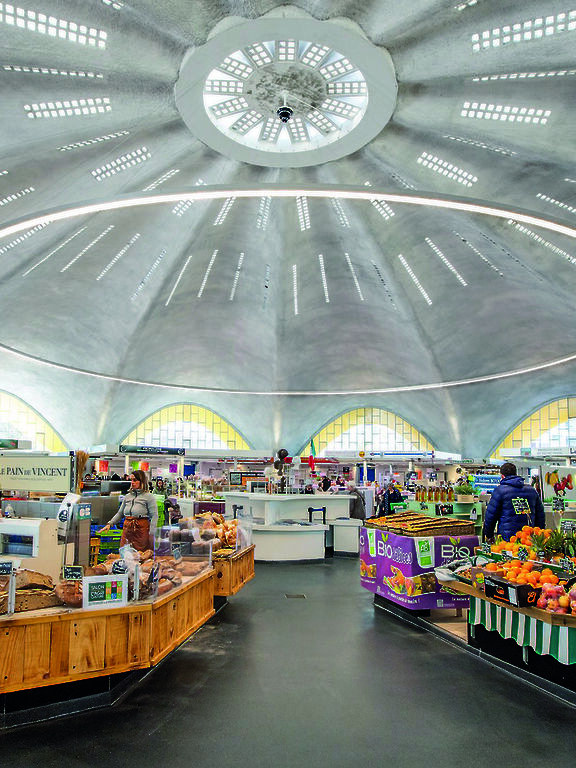 Market hall with stalls, round dome and and customised, large-format ring-shaped Ringo Star pendant luminaire.