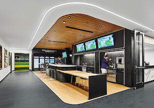 Modern nutrition bar with wooden ceiling, LED strip lighting, screens and beverage station