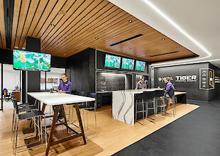 Modern nutrition bar in the LSU training centre with wooden ceiling, LED strip lighting and multiple screens