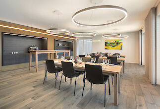 Bright meeting and dining area with wooden tables and large round pendant lights