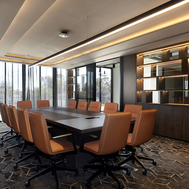 Modern conference room with large table, leather chairs, and Matric pendant light by Lightnet above the table