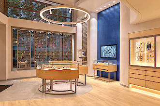 Bright watch boutique with round display cases, Ringo Star pendant light, Midpoint spotlights and wooden surfaces