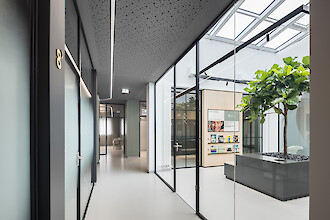 Couloir moderne avec parois vitrées et éclairage de plafond Liquid Line incurvé