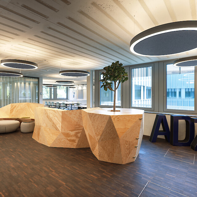 Offener Bürobereich mit Holzskulptur und schwebenden Ringo Star Acoustic Deckenleuchten