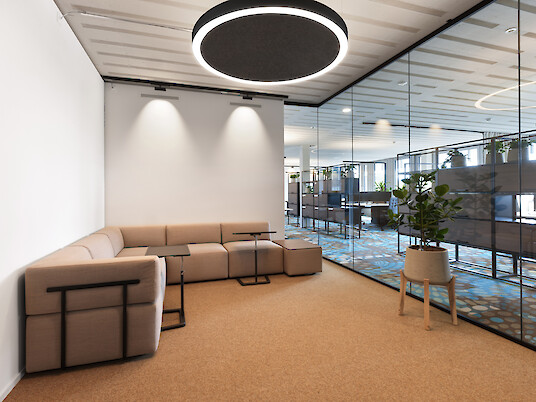 Coin salon avec canapé, paroi vitrée et suspension Ringo Star