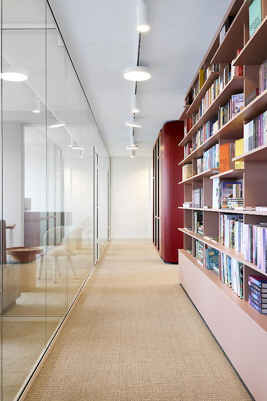 Flur mit Bücherregal, Glaswänden und Lichtschienensystem mit Leuchten und Strahlern