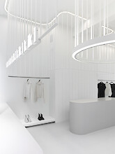 Boutique mit organisch geschwungenen Lichtlinien und runden Leuchten in ruhiger Raumkomposition