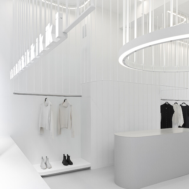 Une boutique aux lignes lumineuses aux courbes organiques et aux luminaires arrondis, dans un aménagement serein