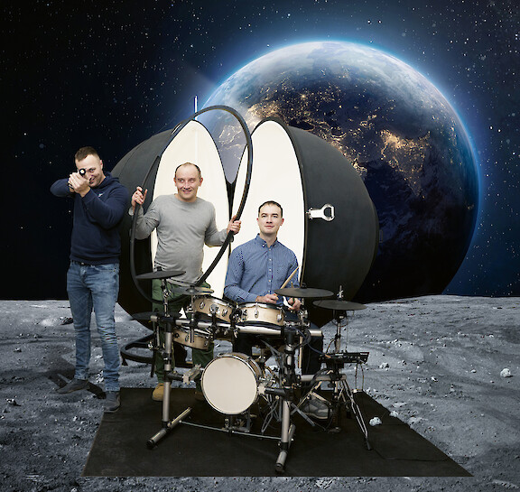 Three Lightnet employees with a light meter and drum set against a space backdrop.
