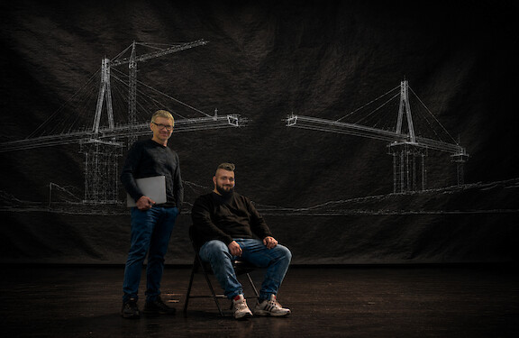 Two Lightnet employees in front of a sketched bridge structure.