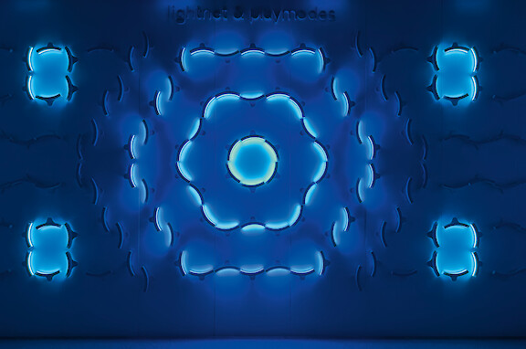Abstract blue light installation with circular and symmetrically arranged illuminated elements.