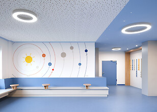 Wartebereich im Krankenhaus mit blauer Raumgestaltung und Ringleuchten an der Decke.