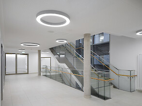 Helles Treppenhaus im Krankenhaus mit Ringleuchten in unterschiedlichen Durchmessern.
