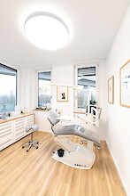 Bright orthodontic treatment room with wooden flooring and Basic X1 luminaire.