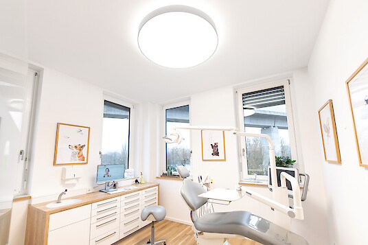 Bright orthodontic treatment room with treatment chair and Basic X1 luminaire.