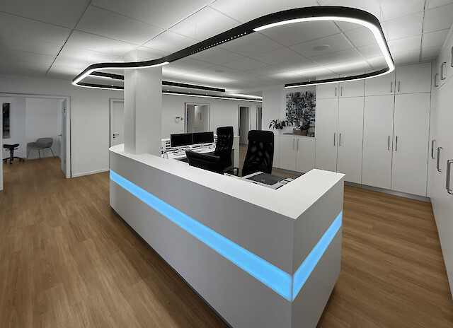 Moderner Praxisempfang mit weißer Theke, blauem Lichtstreifen und Liquid Line PX.