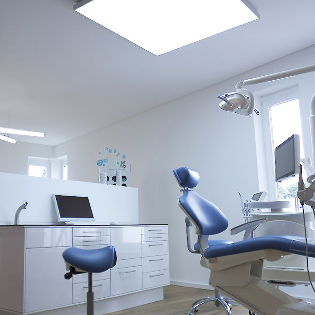 Dental practice with treatment chair and large, rectangular Cubic LED ceiling luminaire.