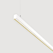 The picture shows a section of a linear white pendant light with a recessed smooth cover. The underside has a gold-coloured reflector ring. The luminaire has a modern design and is suspended from the ceiling on a thin cable. The background is grey.