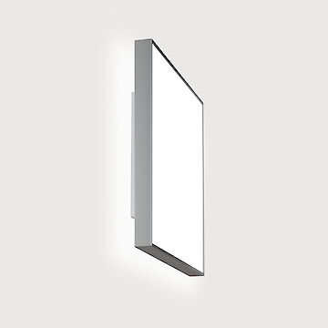 The picture shows a rectangular, modern wall luminaire with a sleek, silver frame. The luminaire is placed in front of a light grey background.
