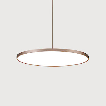 Minimalist, round pendant luminaire with a thin, bronze-coloured frame that shines in a neutral white. The luminaire is suspended from a narrow rod and is set against a neutral, light grey background.