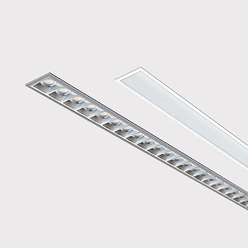 The picture shows a section of two linear recessed luminaires, one with a white and one with a grey edge. Both lights have an elongated, slender and modern design. The background is grey.