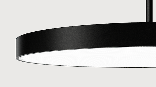 The illustration shows a section of a modern, round pendant luminaire with a flat, black housing. Just over half of the luminaire can be seen. The background colour of the image is a light grey.
