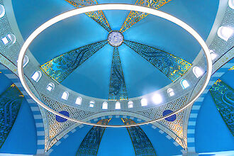 Blue dome of the Ulu Mosque with golden ornaments and large ring-shaped Ringo Star pendant luminaire.