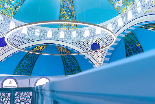 Blue dome of the Ulu Mosque with golden ornaments and large ring-shaped Ringo Star pendant luminaire.