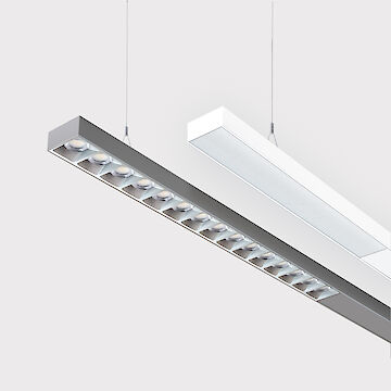 The picture shows a section of two linear pendant luminaires, one with a white and one with a grey surface. The underside of the grey luminaire is fitted with a grey louvre, with each lens containing a small LED light. The black luminaire has a smooth cover. Both luminaires have a modern design and are suspended from the ceiling on thin cables. The background is grey.