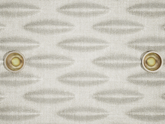 Close-up of an acoustic pendant luminaire. The surface of the luminaire has a structured, wave-like texture and is kept in a light colour. Several small, evenly distributed points of light are integrated into the design and provide discreet lighting.