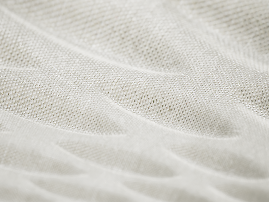 Close-up of an acoustic pendant luminaire. The surface of the luminaire has a structured, wave-like texture and is kept in a light colour.