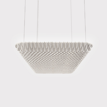 Une grande suspension acoustique rectangulaire suspendue au plafond par quatre câbles fins. La surface du luminaire présente une texture structurée et ondulée, dans une teinte claire. 