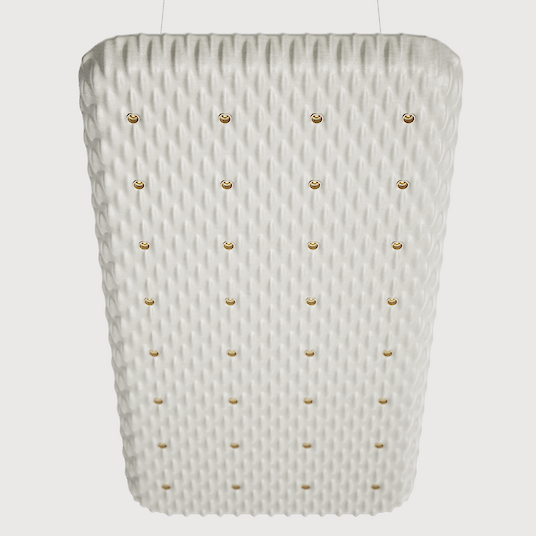 Una gran luminaria acústica rectangular suspendida del techo por cuatro finos cables. La superficie de la luminaria tiene una textura estructurada, ondulada, y se mantiene en un color claro. Varios puntos de luz pequeños, distribuidos uniformemente, están integrados en el diseño y proporcionan una iluminación discreta.