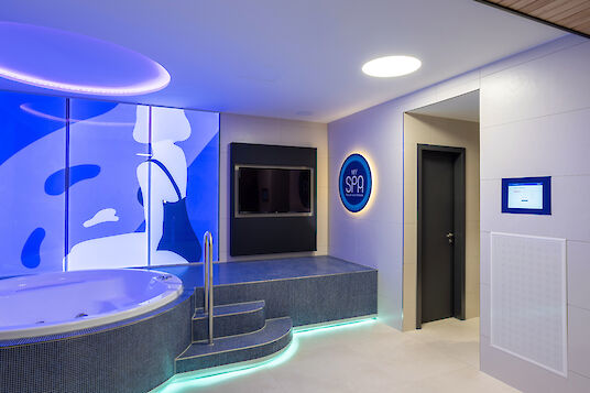 Spa area with whirlpool, blue wall graphics and round Basic recessed luminaire.