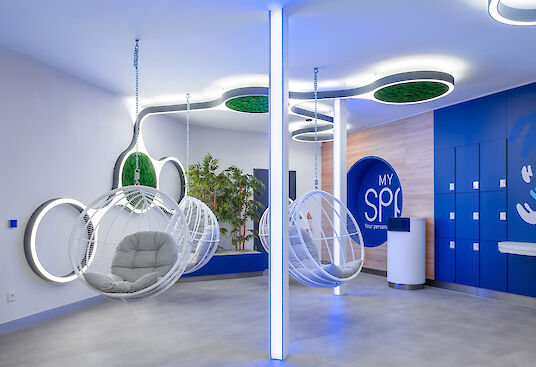Spa lounge area with hanging ball chairs, blue lockers, plants and organic Ringo Star Cluster ceiling luminaires.