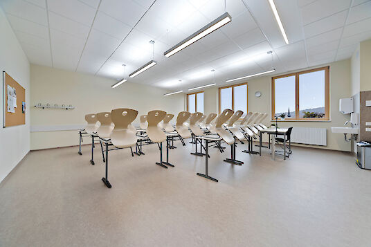 Classroom with high-backed chairs, large windows and linear Vision pendant luminaires.