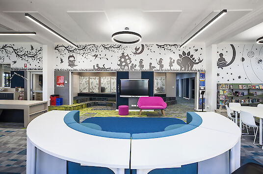 School library with wall graphics, colourful furniture and Ringo Star and Matric pendant luminaires.
