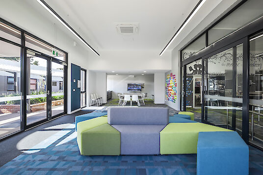 School area with colourful seating, glass walls and linear Matric pendant luminaires.